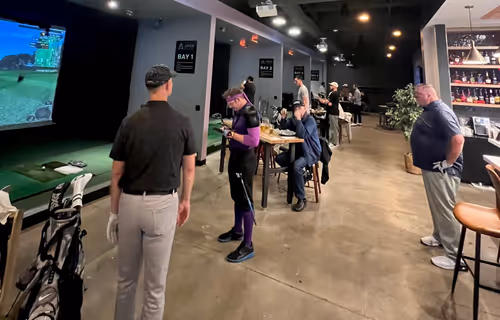 People playing golf in simulator bays