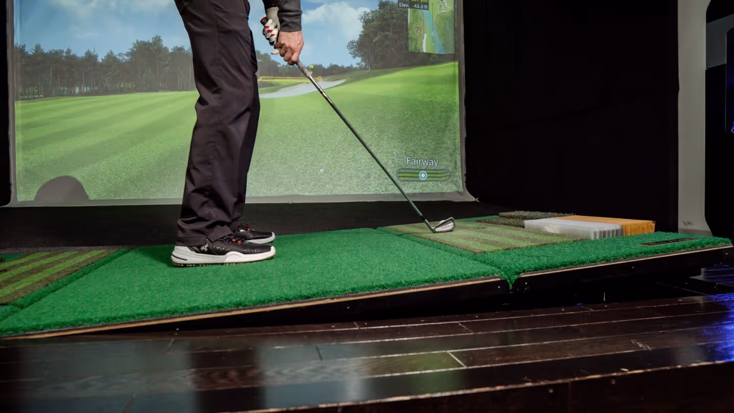 A golfer enjoying a private simulator bay